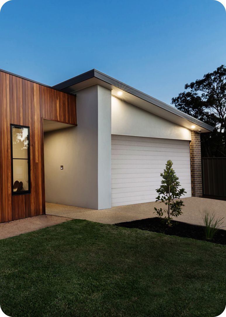Modernes Einfamilienhaus in der Dämmerung mit einem Garagen-Sektionaltor